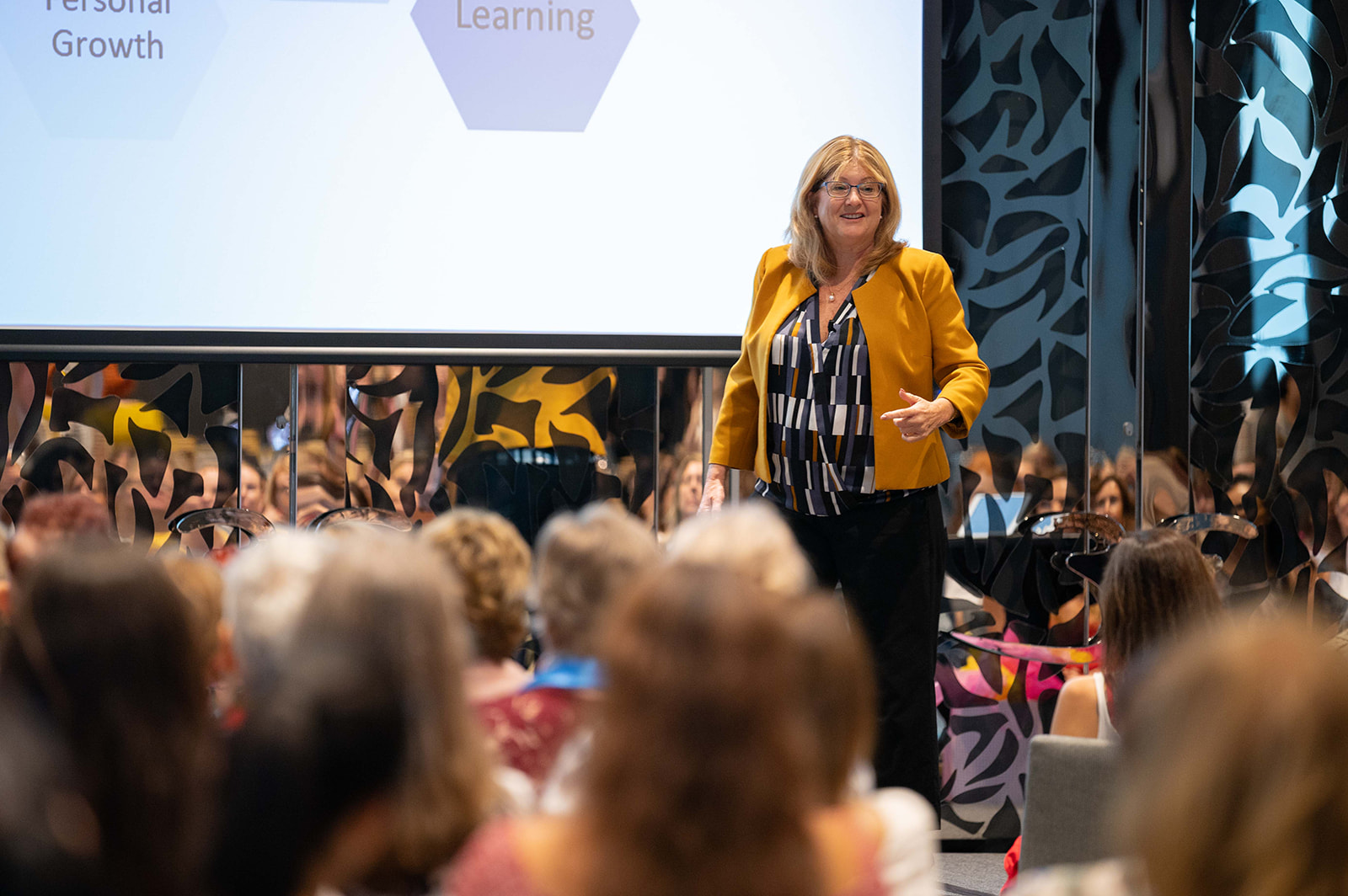an image of Janeen Vosper, speaker and brand authority coach presenting and speaking to a large audience of women at the one woman summit on how to have balance in your life.